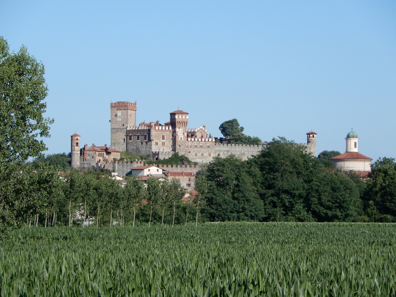A panoramic exterior view of Castello di Pavone and the surrounding countryside